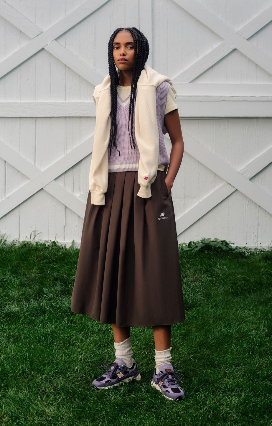 A person standing in front of a set of white barn doors. 